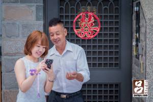 新娘父親和妹妹想要在大門前的囍字拍幾張