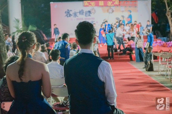 坐在台下觀看前面正在進行合照拍攝的新人