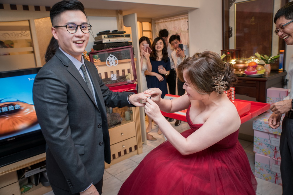 新娘把訂婚戒套在新郎手上
